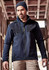 A man wears a navy blue unisex waterproof jacket with a hood. The jacket has a logo and is styled for casual wear.