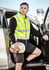 A unisex high visibility softshell vest in bright yellow with black accents, featuring reflective stripes.