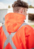 A heavy-duty waterproof jacket in bright orange with reflective silver X-back detailing, featuring a hood.