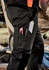 Men's work pants in black, featuring multiple pockets for tools and a visible logo, set outdoors.