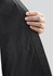 A hand holds the edge of a Women's Tempest Jacket, showcasing its black fabric texture and design.
