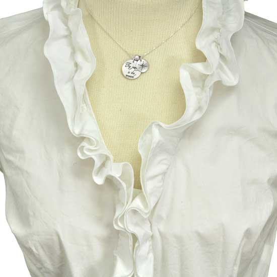 Custom sterling silver necklace with "The Journey is the Reward" stamped in script, with another charm showing compass points, shown on model