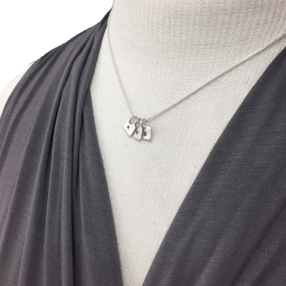 Sterling silver personalized initial necklace with tiny squares on model