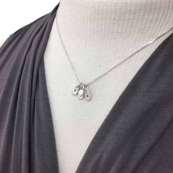 Hand stamped fine silver initial charms for mom on model