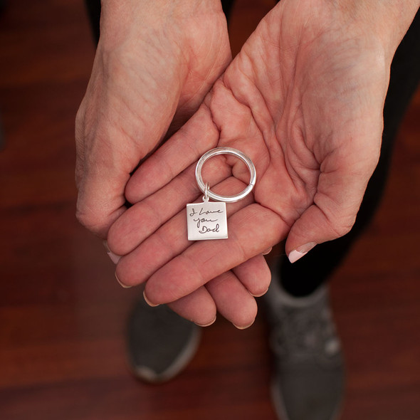 model holding custom silver keyring personalized with with Dad's handwritten signature