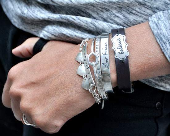 Stacked personalized bracelets, with silver personalized hand stamped coordinates bracelet, shown on model