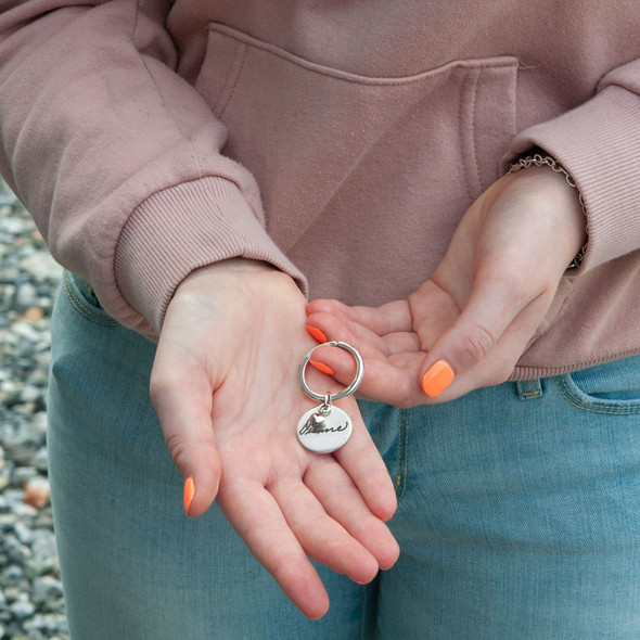 Model holding custom handwriting sterling silver key chain, personalized with loved one's handwritten note