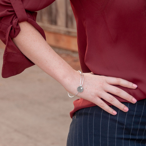 Adjustable sterling silver bracelet with custom fingerprint charm, shown on a model