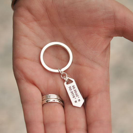 Custom hHand stamped longitude latitude silver key ring, shown in a hand