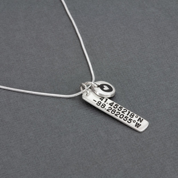 Side view of Custom silver hand stamped coordinates necklace, personalized with the location of a special place, with etched heart charm