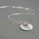 Memorial silver hand stamped necklace shown from the side, with a copper and silver heart