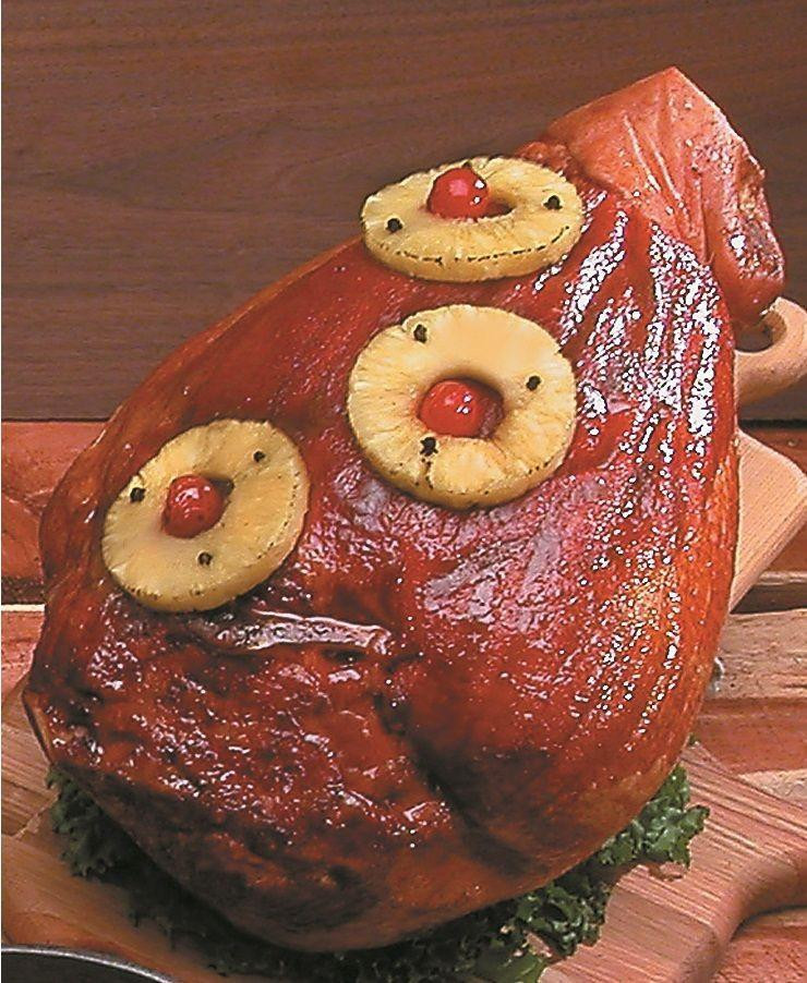 Cherry Smoked Sugar Cured Ham (Half), a whole glazed ham decorated with pineapple rings topped with maraschino cherries and cloves, served on a wooden platter.