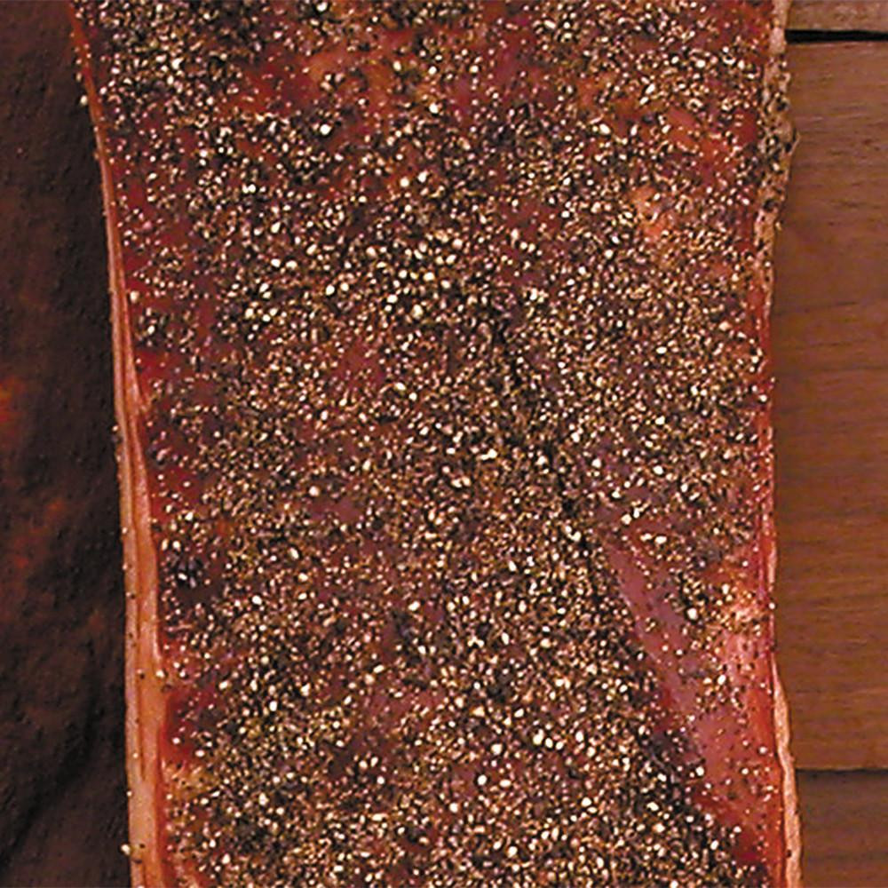 Sugar Cured Hickory Smoked Peppered Bacon - 1lb Package, close-up of seasoned bacon with peppercorn crust.