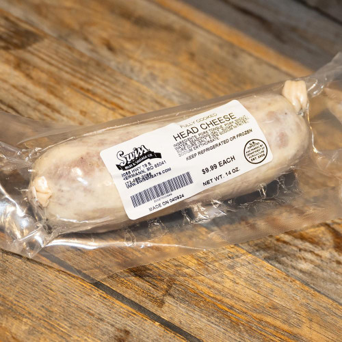 Schwartenmagen Head Cheese - 14oz, fully cooked head cheese in vacuum-sealed packaging on a wooden surface.