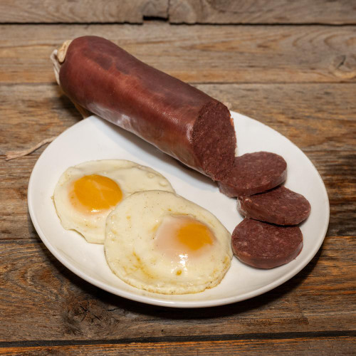 Blood Sausage (Blutwurst), sliced blood sausage with two fried eggs on a white plate.