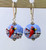 Powder blue lampworked "lentil" shaped earrings with cardinals