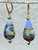 Opaque periwinkle swirled roses on light blue and gold foil flattened tear drop Venetian glass earrings