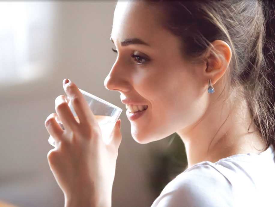 Woman drinking alkaline water looking refreshed and happy