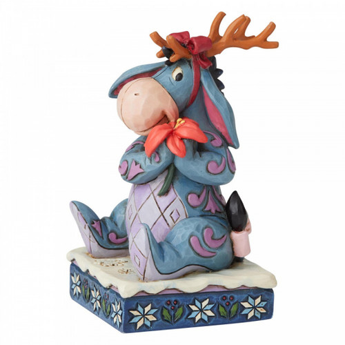 Disney Traditions Eeyore from Winnie the Pooh wears antlers and carries a poinsettia figurine