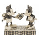 Disney Traditions Monochrome Mickey Mouse giving Minnie a heart shaped box with flowers hidden behind his back figurine.