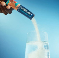 Pouring Grapefruit Liquid I.V. powder into a glass of water