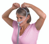 Woman putting on ResMed Swift FX For Her Nasal Mask