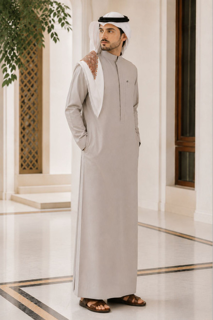 Man wearing a traditional beige thobe with a white hood in an indoor setting.