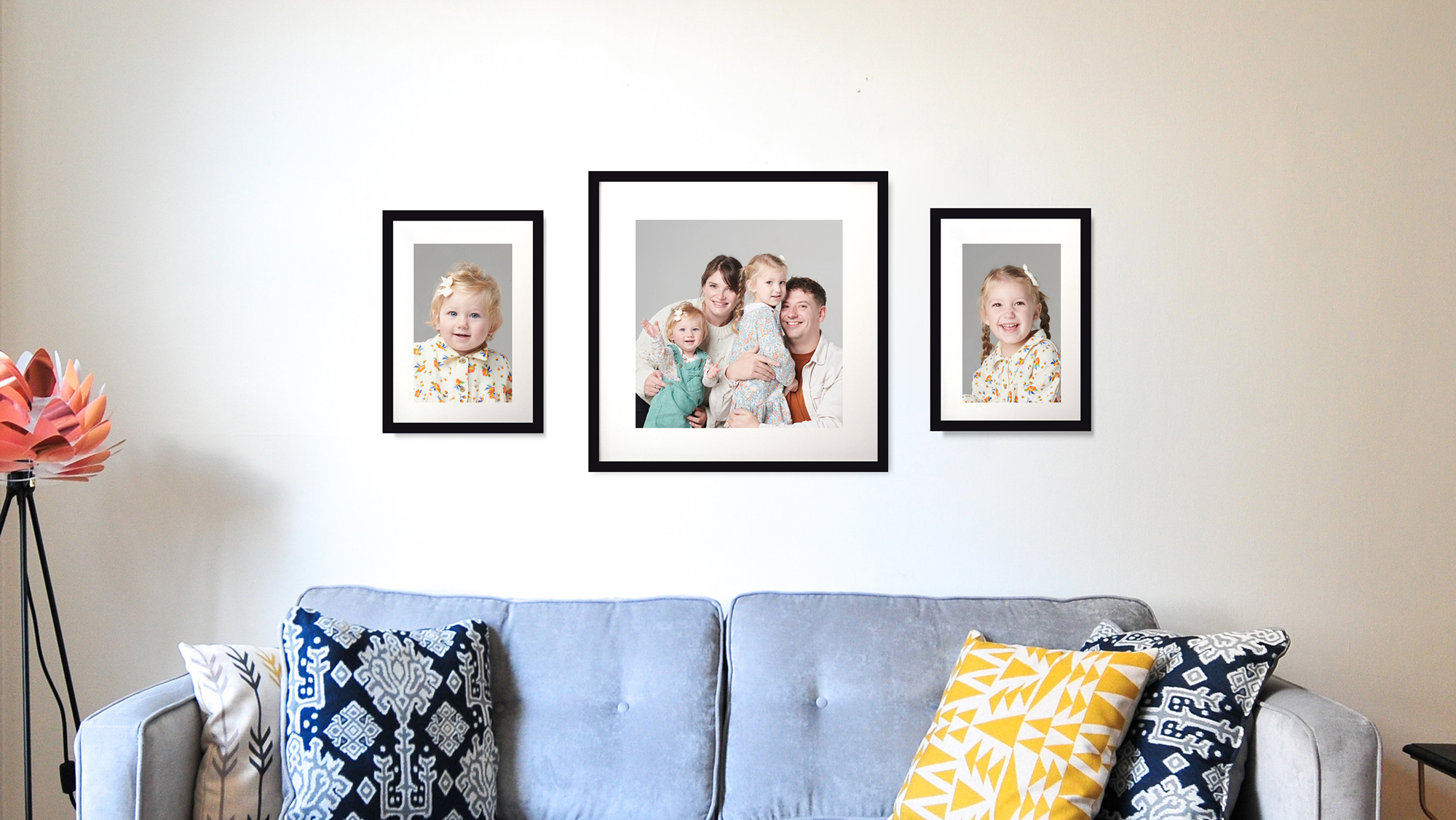 Framed portrait set of family on a wall above a sofa