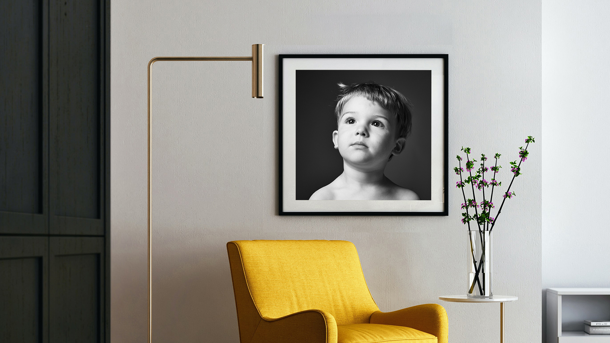 Black and White photograph of a little boy in a black frame hanging on a wall