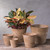 Grouping of five round taupe planters with four empty and one planted
