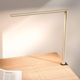 Lampe de bureau ofinto Lumino Desk sable avec pince de table noire (en option) – lampe LED sur un bureau en bois avec un magazine ouvert ; éclairage de poste de travail moderne et minimaliste