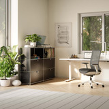 Meuble bas Cubox 3 niveaux, 4 abattants en noir dans un bureau à domicile lumineux avec plantes et grande fenêtre