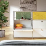 Meuble Cubox avec Soft Panels vert mousse et jaune soleil, corps blanc, dans un salon lumineux avec plante et parquet
