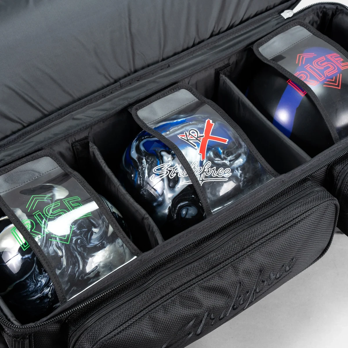 Three bowling balls in padded dividers inside KR Strikeforce Diamond Dually triple roller