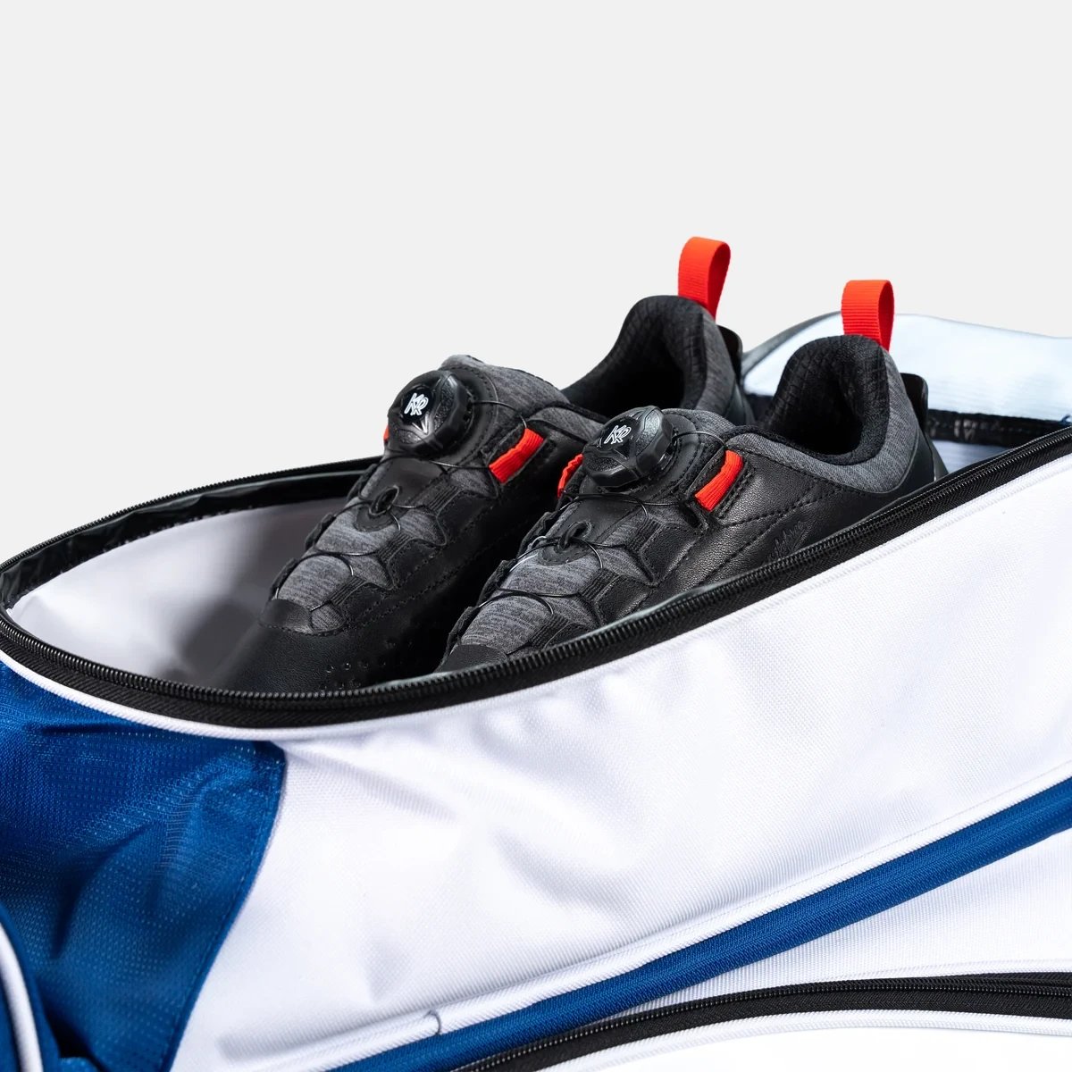 Bowling shoes in shoe compartment of royal/white KR Strikeforce Drive Dually roller bag