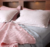 Styling image with the Musk pink Coverlet as a blanket, and showing the Vintage Linen bed sheets as a combination set.