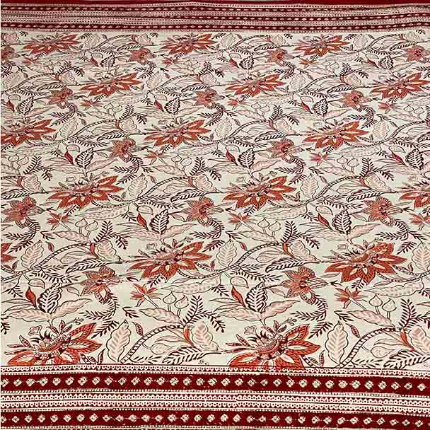 Lotus design floral tablecloth, featuring burnt reds and rusty tones on a white background that creates drama in the design.