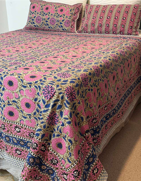 Hand block-printed 100% organic cotton bed sheet and pillowcase set, which features large stylised daisy designs in pinks, coffee tones and indigo blues.