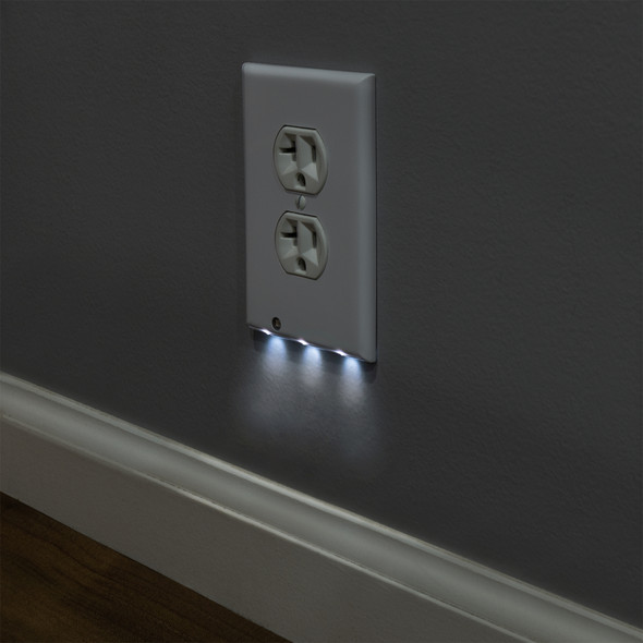 White outlet cover installed on a wall with the lower nightlight on.