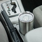 Stainless steel 20 ounce vacuum tumbler sitting in a cup holder in the car.