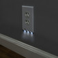 White outlet cover installed on a wall with the lower nightlight on.
