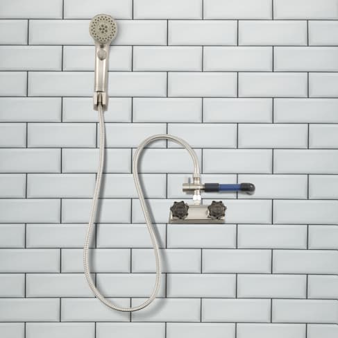 Showermiser installed in a shower with  a brushed nickel shower head and hose.