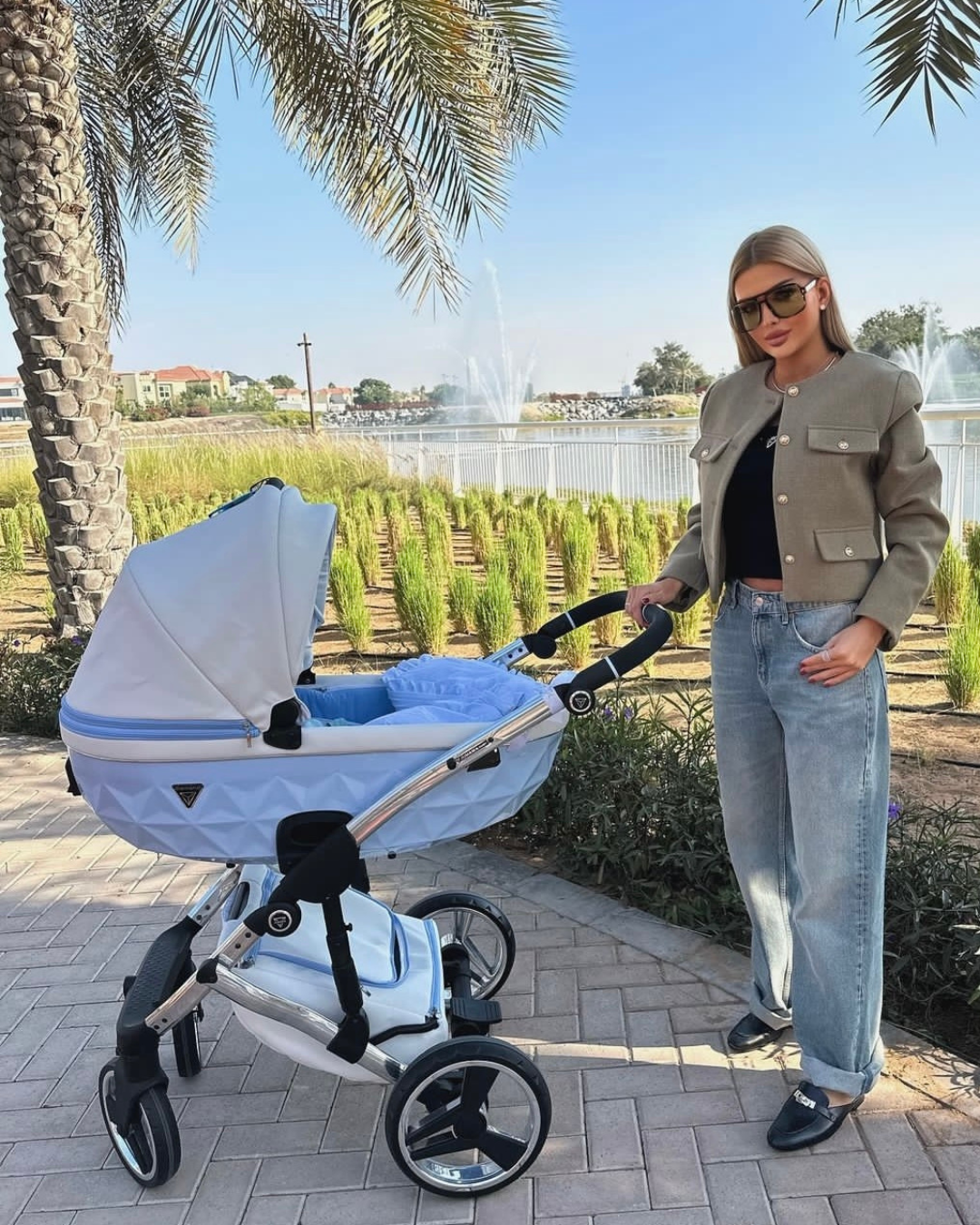 Junama Candy Blue 2-in-1 pram with glamorous  mum standing next to the pram in neutral setting