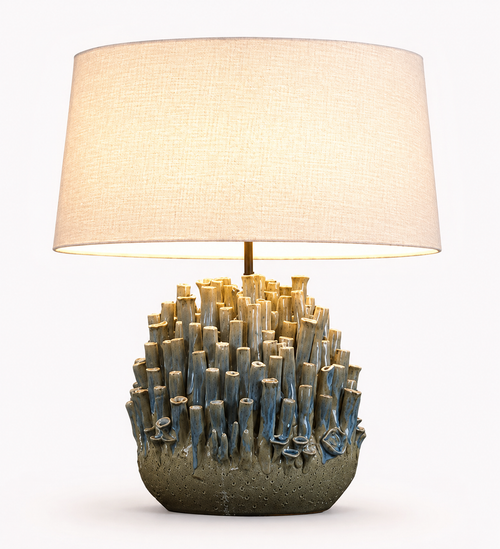 Handmade Thai sea anemone ceramic table lamp with sculpted earth tone base, soft blue accents, and white textured linen shade on white background
