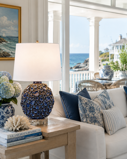 Handmade Thai blue oyster ceramic table lamp styled on a side table in a bright coastal interior