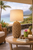 Pier Weave rope table lamp L120 styled on a coastal veranda, showing the handcrafted open-weave rope base and natural shade.