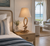 Marina Curve rope table lamp L135 styled in a bright bedroom interior with its looped Manila rope silhouette and neutral shade fully visible.