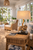 Anchor natural rope table lamp L138 styled on a side table in a bright coastal interior with its anchor base and neutral shade clearly visible.