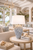 Blue and cream sea anemone ceramic table lamp displayed beside seating in a bright sophisticated coastal living room
