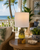 Small yellow pineapple ceramic table lamp with wooden base styled on a tropical lanai or veranda